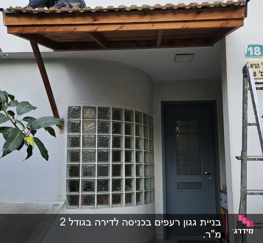 אדם עובד על גג עץ קטן מעל כניסה לבית
